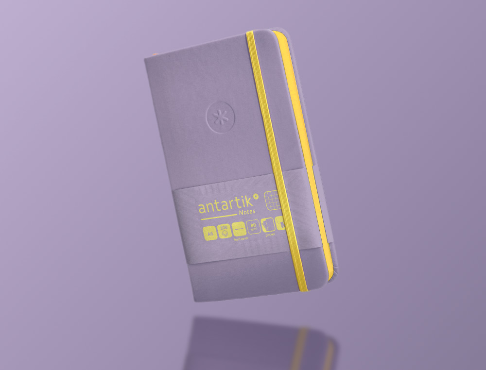 CUADERNO CON GOMILLA ANTARTIK NOTES TAPA DURA A6 HOJAS CUADRICULA MORADO Y AMARILLO 100 HOJAS 80 GR FSC